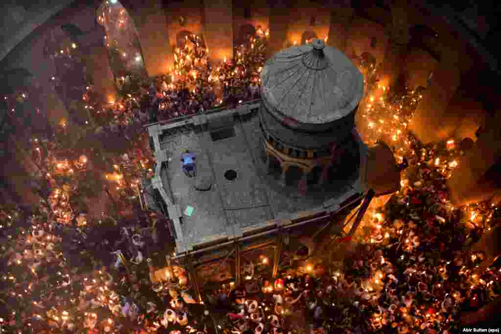 Основна заслуга появи наступного кадру &ndash; особисті зв&#39;язки фотографа ЕРА Абір Султана: без них йому не вдалося б зняти церемонію запалювання благодатного вогню в Храмі Гробу Господнього в Єрусалимі. &laquo;Я дуже добре знаю заступника патріарха, тому я попросився в нього піднятися наверх і поспостерігати за церемонією&raquo;, &ndash; розповідає фотограф. Він уже багато разів бував на цій точці, але саме в цей Абір відчував, що в нього має вийти особливий кадр. Він побачив, як чоловік забрався на дах Гробу. &laquo;Він припав до землі, немов молиться мусульманин. Лише на секунду&raquo;. І Абір вдалося натиснути на кнопку в потрібний момент.