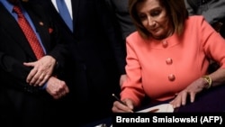 Spiker Nancy Pelosi ittihamnaməni imzalayır